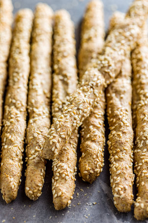 Italian grissini bread sticks with sesame seeds on the kitchen table.の写真素材
