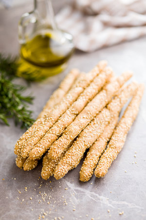 Italian grissini bread sticks with sesame seeds on the kitchen table.