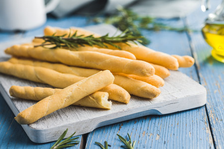 Italian grissini bread sticks on the blue table.の写真素材