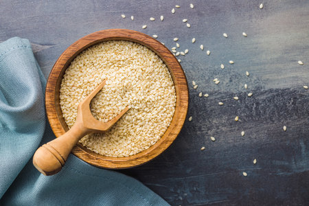 Dried sesame seeds in the wooden bowl. Top view.