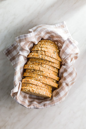 Sliced whole grain bread. Tasty wholegrain pastry with seeds in the bucket. Top view.の写真素材