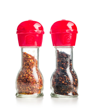 Dry chili pepper flakes. Crushed red peppers in mill isolated on the white background.の写真素材