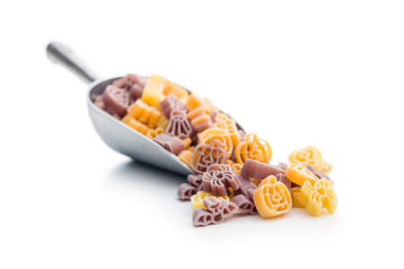 Pasta of various scary shapes. Uncooked Halloween pasta in the scoop isolated on white background.の写真素材