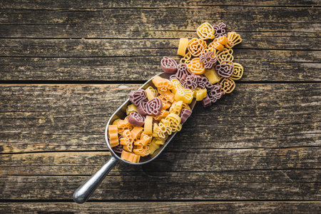 Pasta of various scary shapes. Uncooked Halloween pasta in scoop on the wooden table. Top view.の写真素材