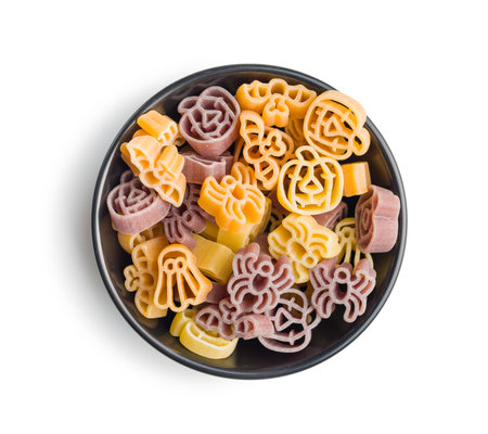 Pasta of various scary shapes. Uncooked Halloween pasta in the bowl isolated on white background.の写真素材