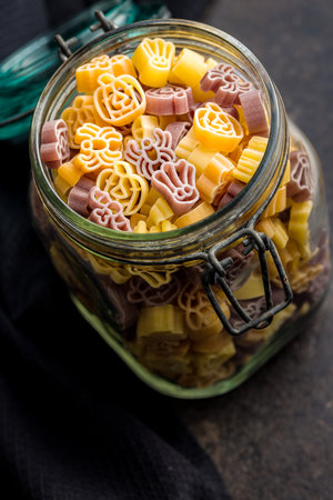 Pasta of various scary shapes. Uncooked Halloween pasta in a jar.の写真素材