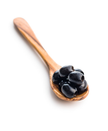Pitted black olives in spoon isolated on the white background.の写真素材