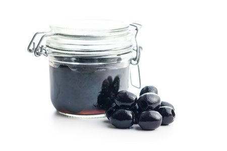 Pitted black olives in jar isolated on white background.の写真素材