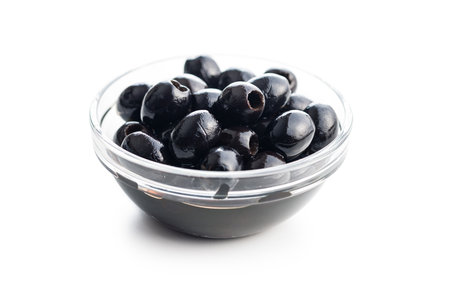 Pitted black olives in a bowl isolated on the white background.の写真素材