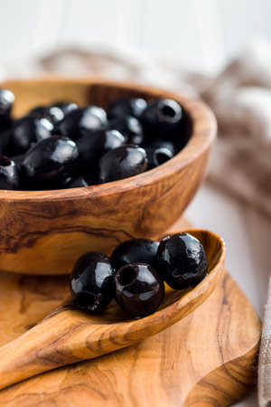 Pitted black olives in the wooden spoon.の写真素材