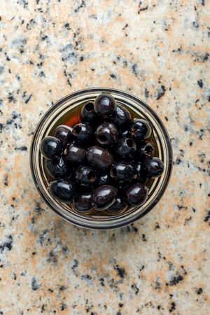 Pitted black olives in a bowl on the kitchen table. Top view.の写真素材