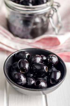 Pitted black olives in a bowl on the kitchen table.の写真素材