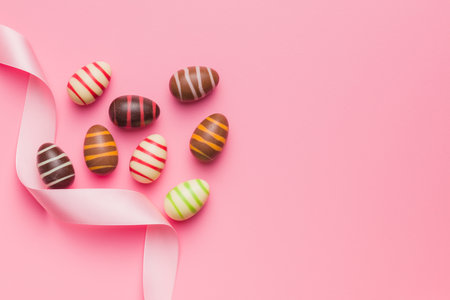 Chocolate easter eggs on the pink background. Top view.