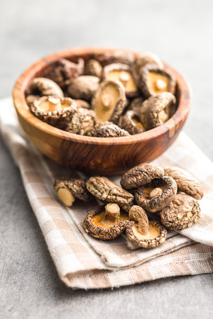 Dried shiitake mushrooms in a bowl on the kitchen table.の写真素材