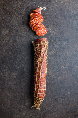 Smoked sausage. Sliced salami on the black table. Top view.の写真素材