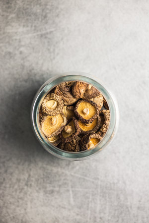 Dried shiitake mushrooms in a jar on the kitchen table. Top view.の写真素材