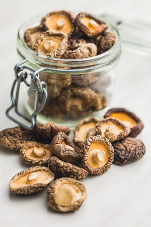 Dried shiitake mushrooms in a jar on the kitchen table.の写真素材