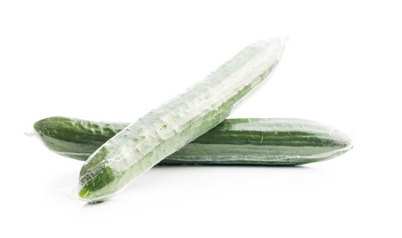 Fresh green cucumbers wrapped in plastic wrap isolated on the white background.の写真素材