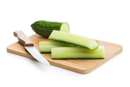 Sliced fresh green cucumber on cutting board isolated on the white background.の写真素材
