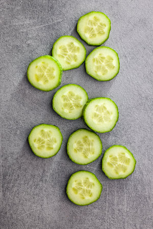 Sliced fresh green cucumber on the kitchen table. Top view.の写真素材
