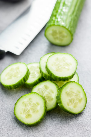 Sliced fresh green cucumber on the kitchen table.の写真素材