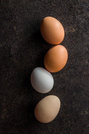 Whole chicken eggs on the black table. Top view.の写真素材
