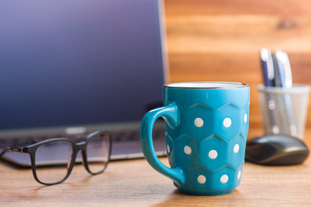 The polka dot mug on the office table.の写真素材