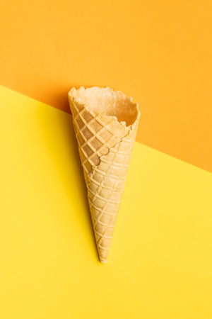 Empty wafer cone. Sweet ice cream cone on colorful background. Top view.の写真素材