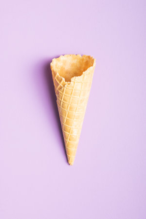 Empty wafer cone. Sweet ice cream cone on the violet background. Top view.の写真素材