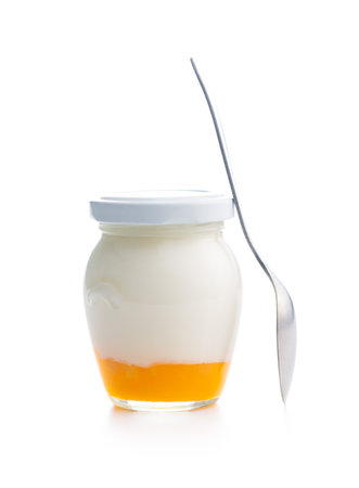 Fruity yogurt in jar and spoon isolated on the white background.の写真素材