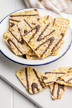 Puffed corn crackers chocolate covered on the white table.の写真素材