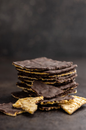 Puffed corn crackers chocolate covered on the black table.の写真素材
