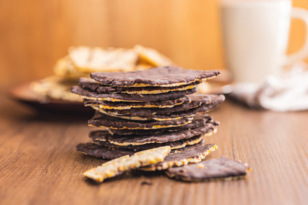 Puffed corn crackers chocolate covered on the wooden table.の写真素材