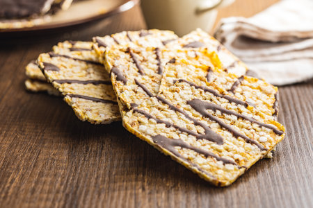 Puffed corn crackers chocolate covered on the wooden table.の写真素材