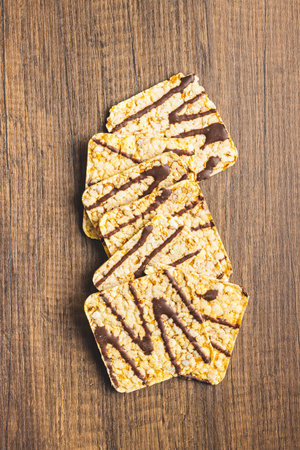 Puffed corn crackers chocolate covered on the wooden table. Top view.の写真素材