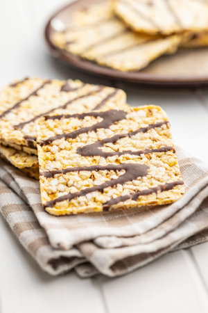 Puffed corn crackers chocolate covered on the white table.の写真素材