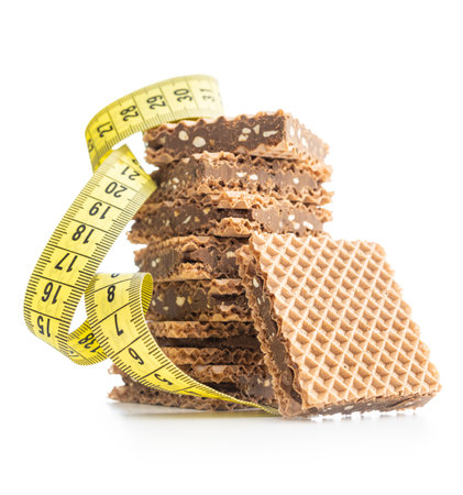 Sweet chocolate wafer and measuring tape isolated on the white background.の写真素材