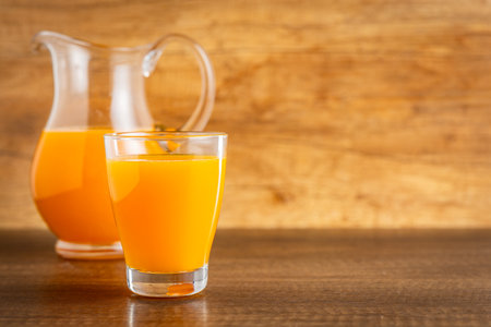 A glass of fruit juice. Orange juice on the wooden table.の写真素材