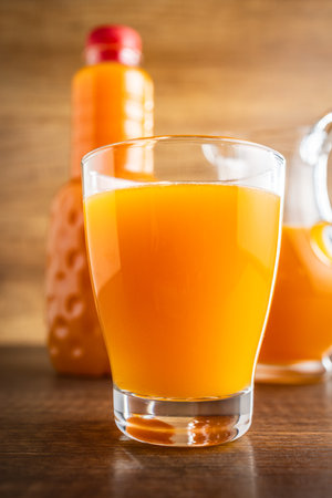A glass of fruit juice. Orange juice on the wooden table.の写真素材