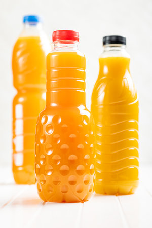 A plastic bottle of fruit juice. Orange juice on the white table.の写真素材