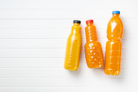 A plastic bottle of fruit juice. Orange juice on the white table. Top view.の写真素材