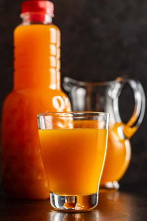 A glass of fruit juice. Orange juice on the black table.の写真素材