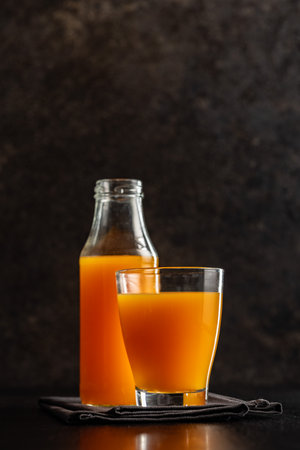 A glass of fruit juice. Orange juice on the black table.の写真素材