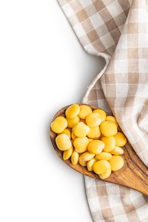 Lupini beans in brine. Pickled lupine in wooden spoon isolated on the white background.の写真素材