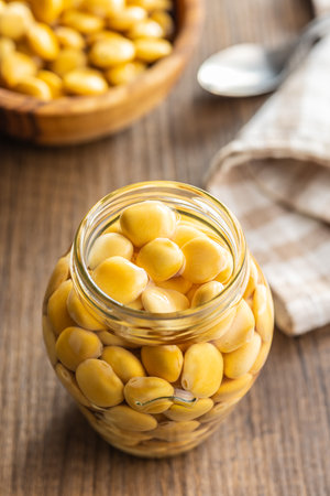 Lupini beans in brine. Pickled lupine in jar on the kitchen table.の写真素材
