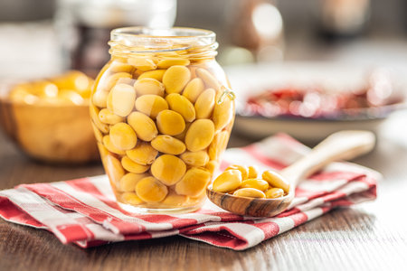 Lupini beans in brine. Pickled lupine in jar on the kitchen table.の写真素材