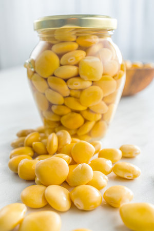 Lupini beans in brine. Pickled lupine in jar on the kitchen table.の写真素材