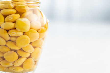 Lupini beans in brine. Pickled lupine in jar on the kitchen table.の写真素材