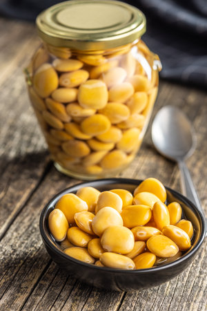 Lupini beans in brine. Pickled lupine in bowl on the wooden table.の写真素材
