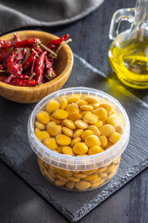 Lupini beans in brine. Pickled lupine in bowl on the black table.の写真素材